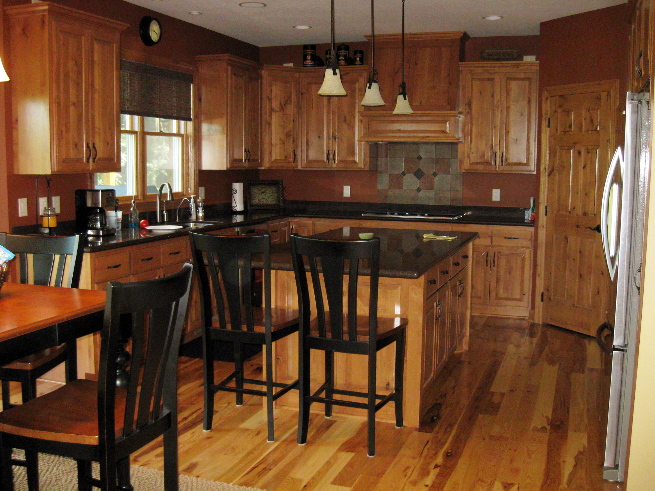New kitchen with wood cabinets and dark stone countertops