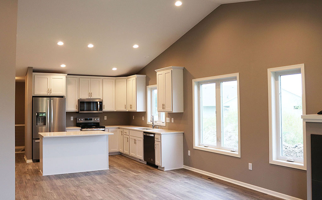 Twin home living and kitchen with vaulted ceiling