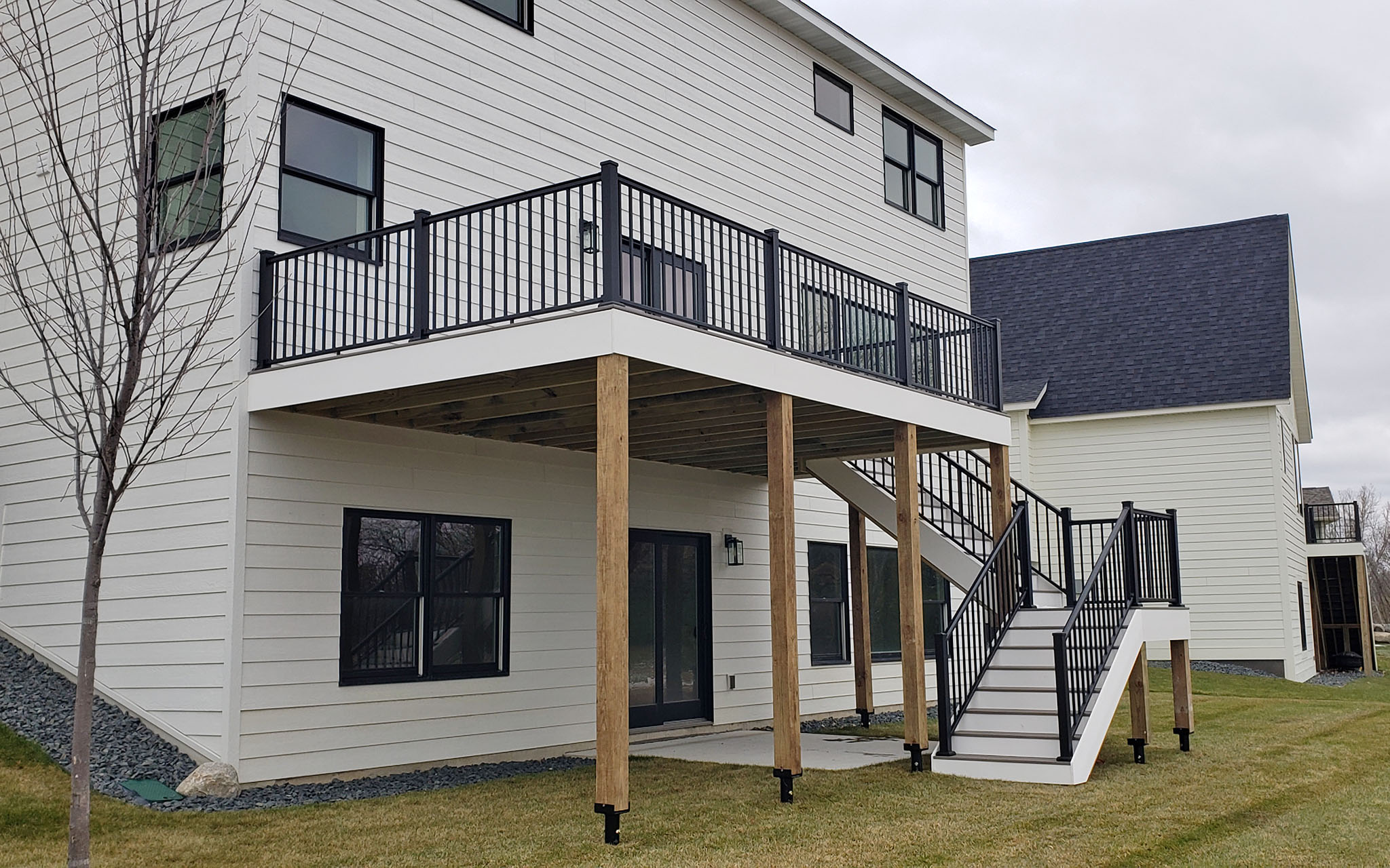 TimberTech composite decking with helical posts, metal balusters, stairway with landing to ground elevation