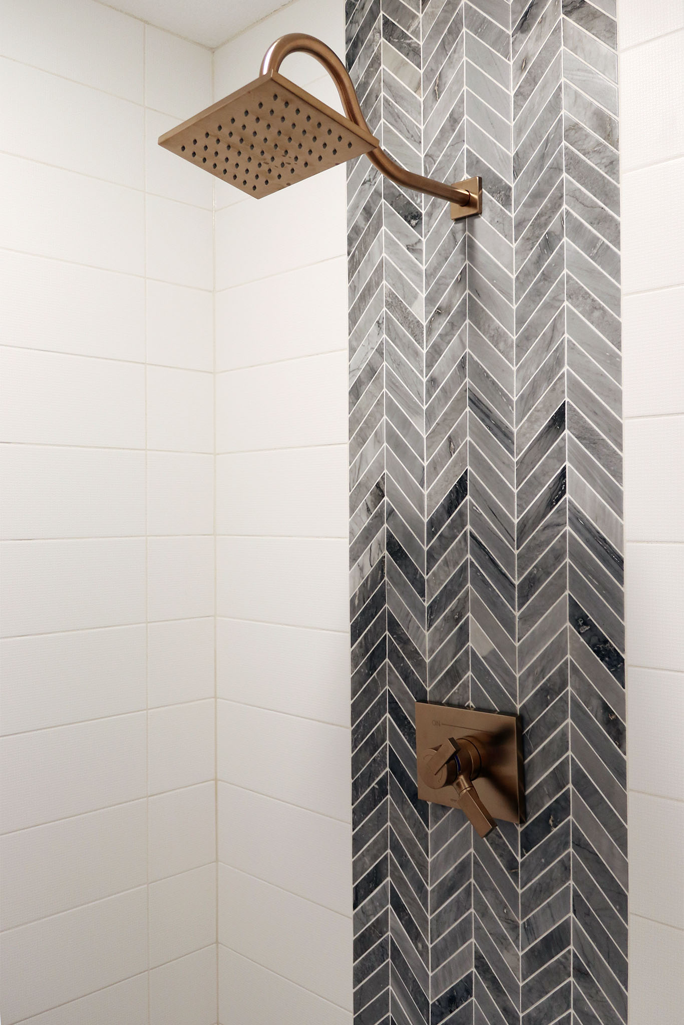 Walk-in ceramic tile shower with decorative ceramic accent tile and rain shower head